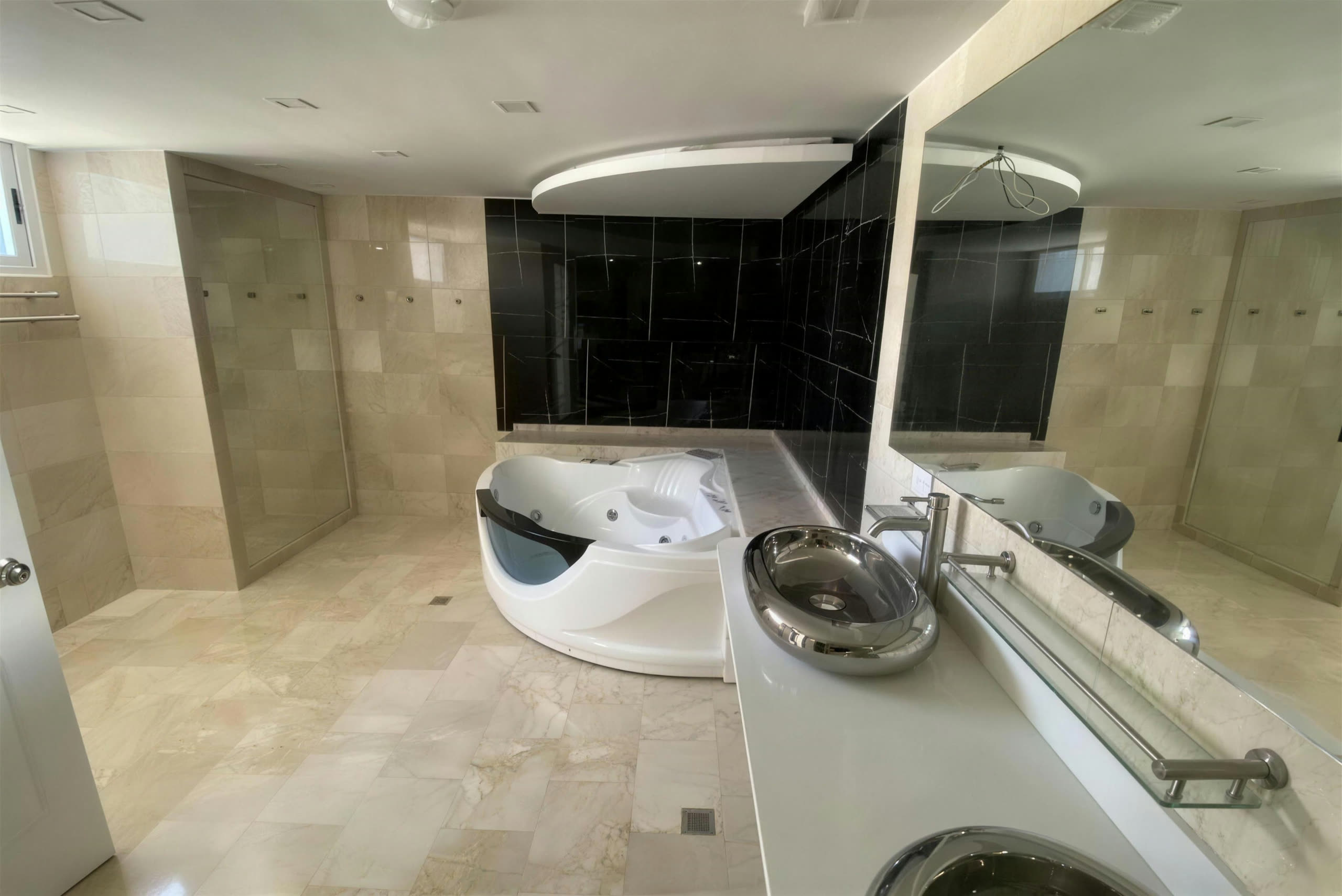 Baño amplio en mármol crema con jacuzzi de esquina