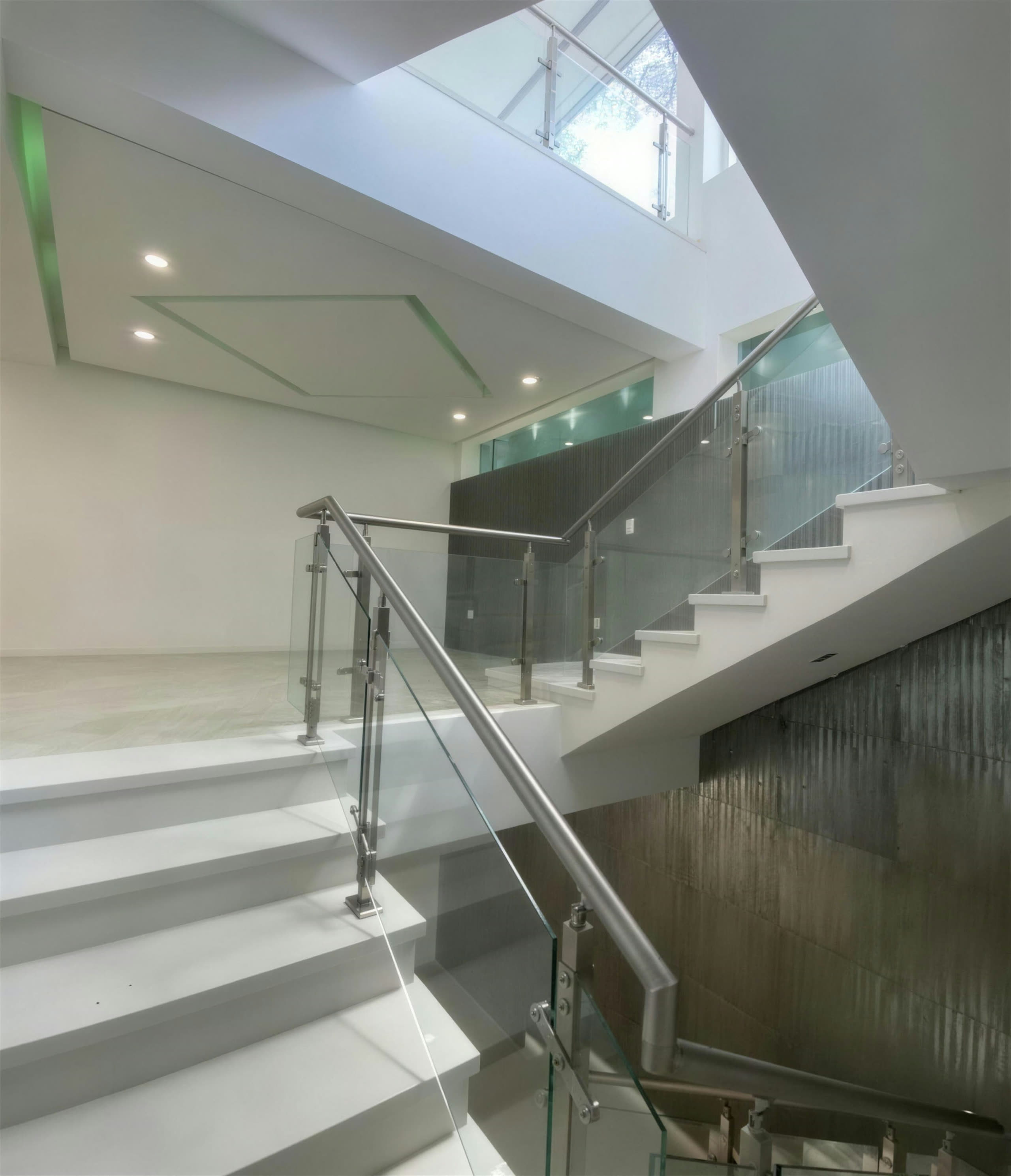 Escalera con tragaluz, vidrio y muros de piedra