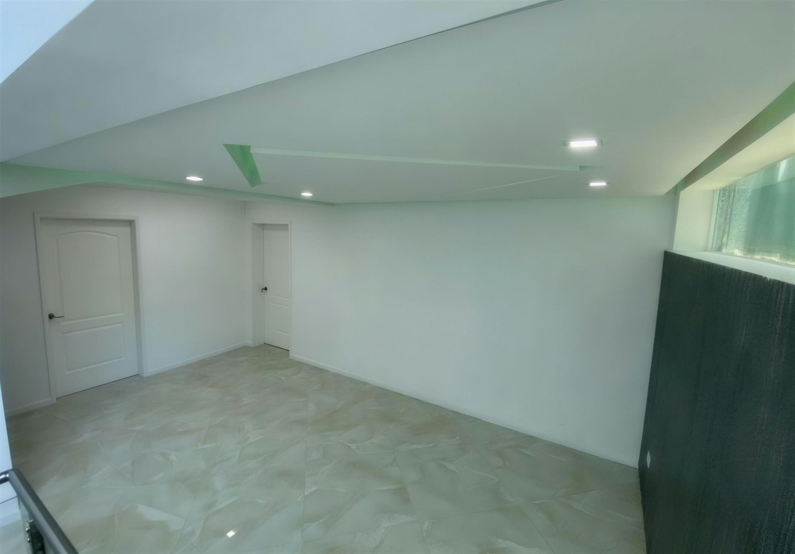 Antesala con lavamanos de piedra y puertas del sauna y vapor