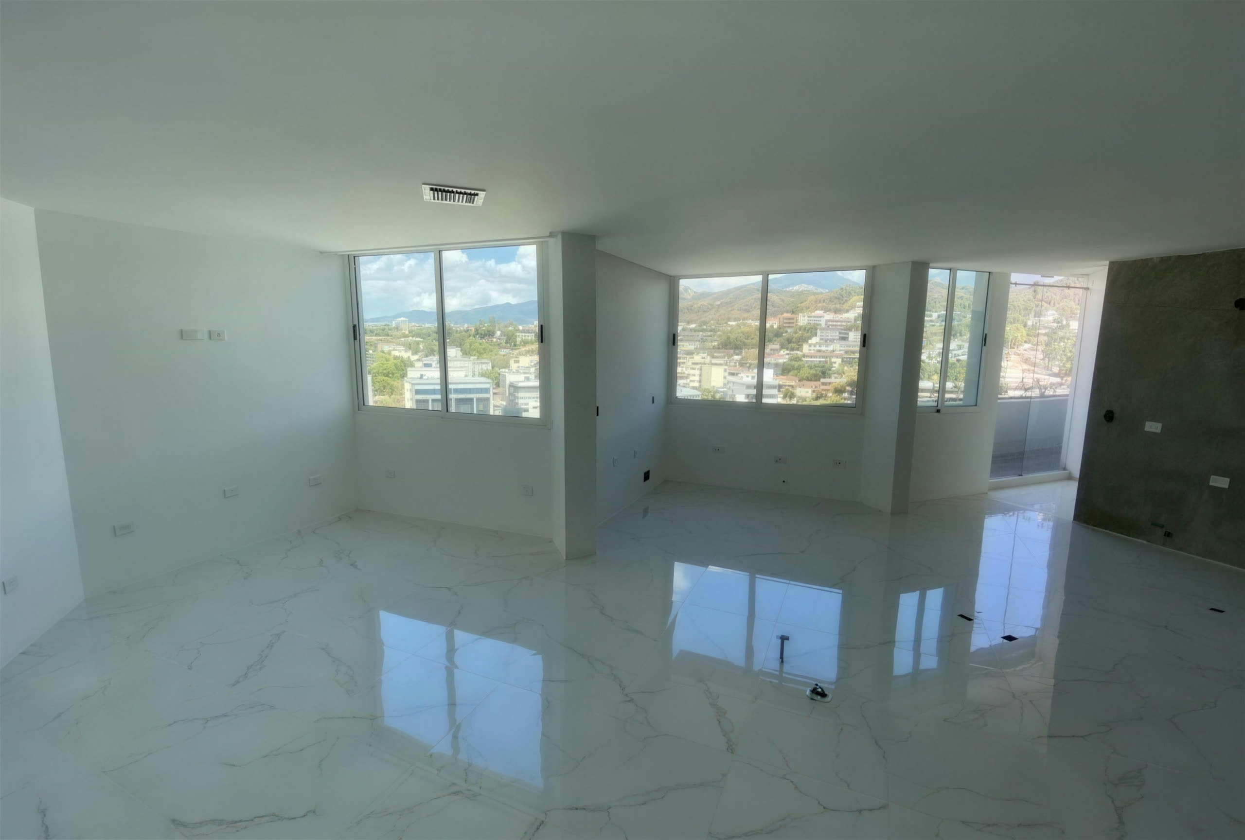 Habitación con piso de porcelanato pulido y ventanales con vista panorámica a las colinas de Caracas