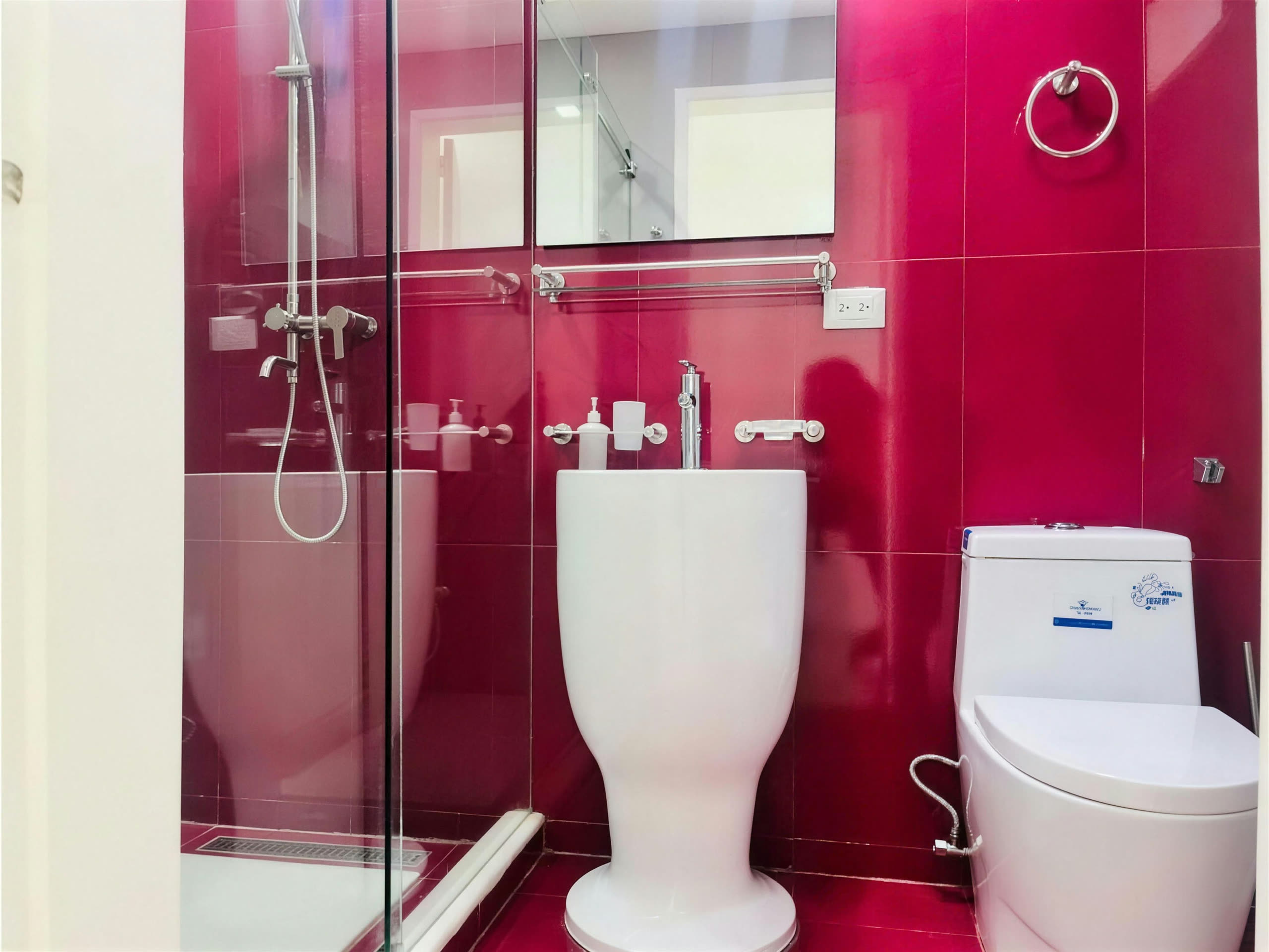 Baño con paredes rojas lacadas y ducha de vidrio
