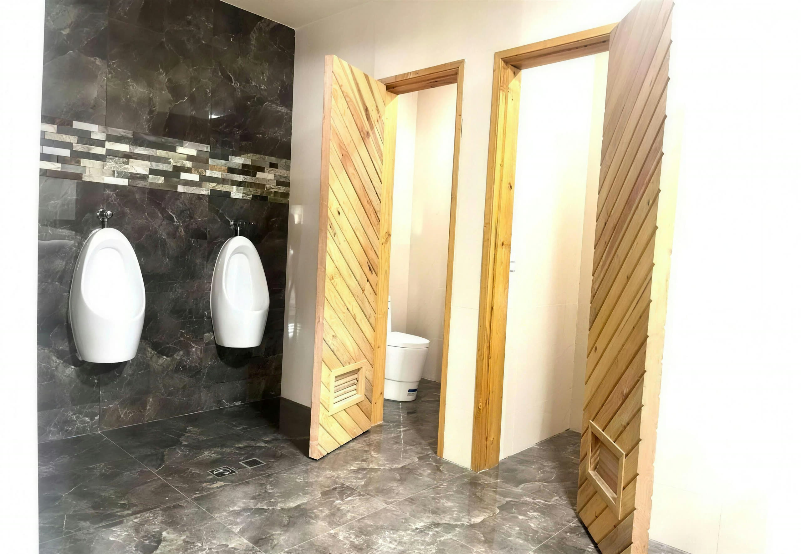 Baños del salón de fiestas con urinarios y puertas de madera