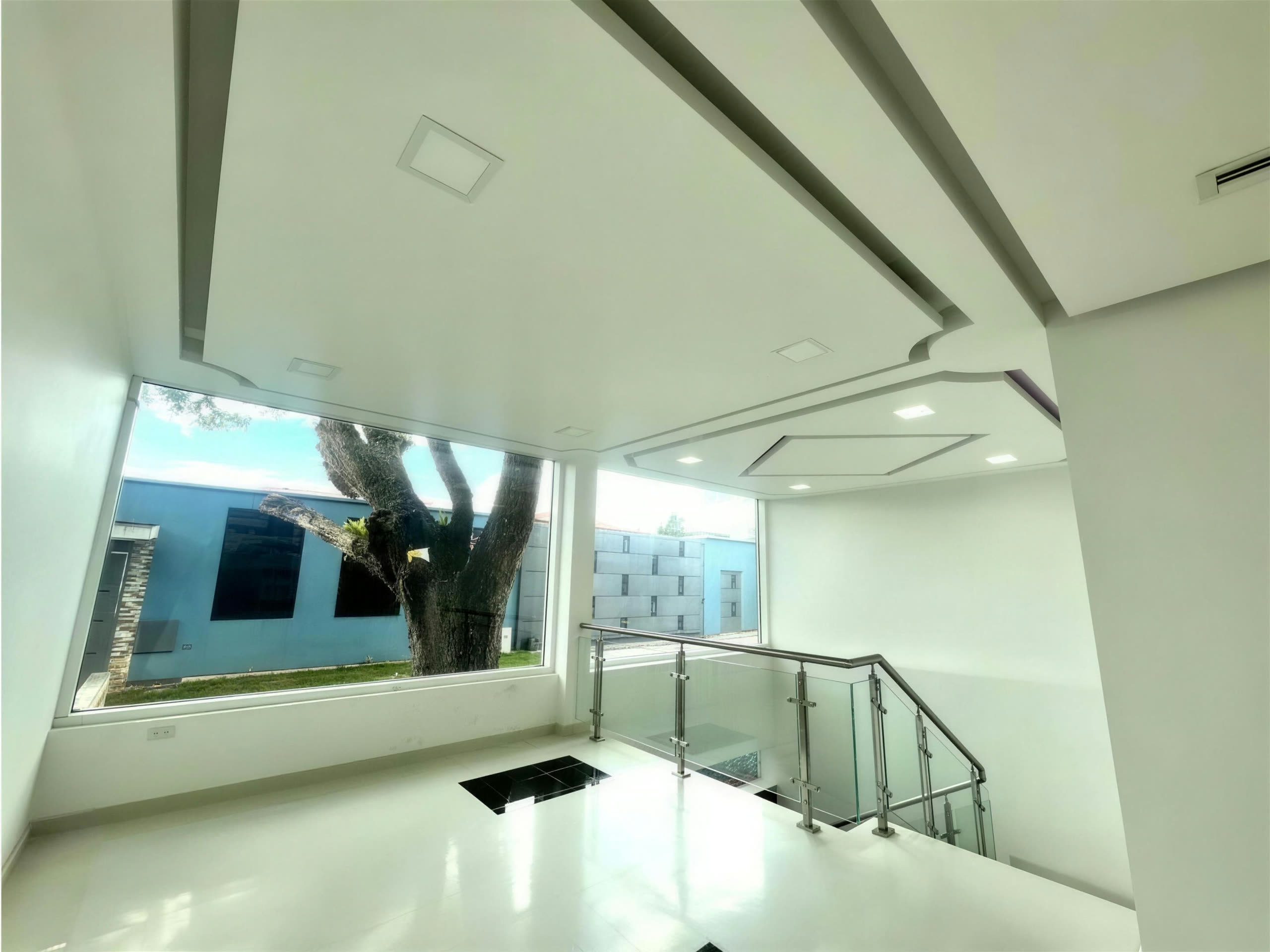 Sala con escalera y vista al jardín por el ventanal