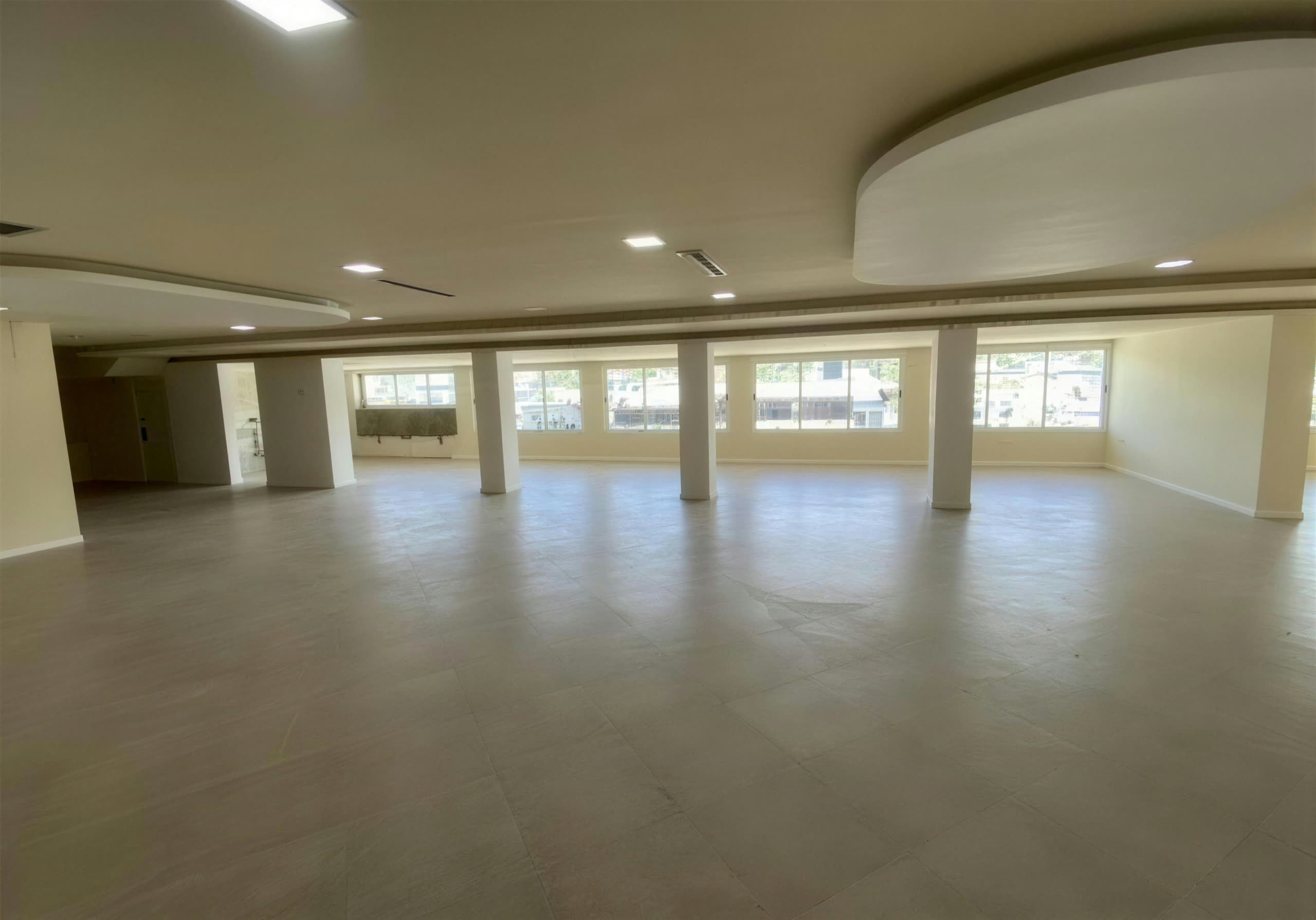 Salón de fiestas del tercer nivel: planta libre con columnas y ventanales corridos