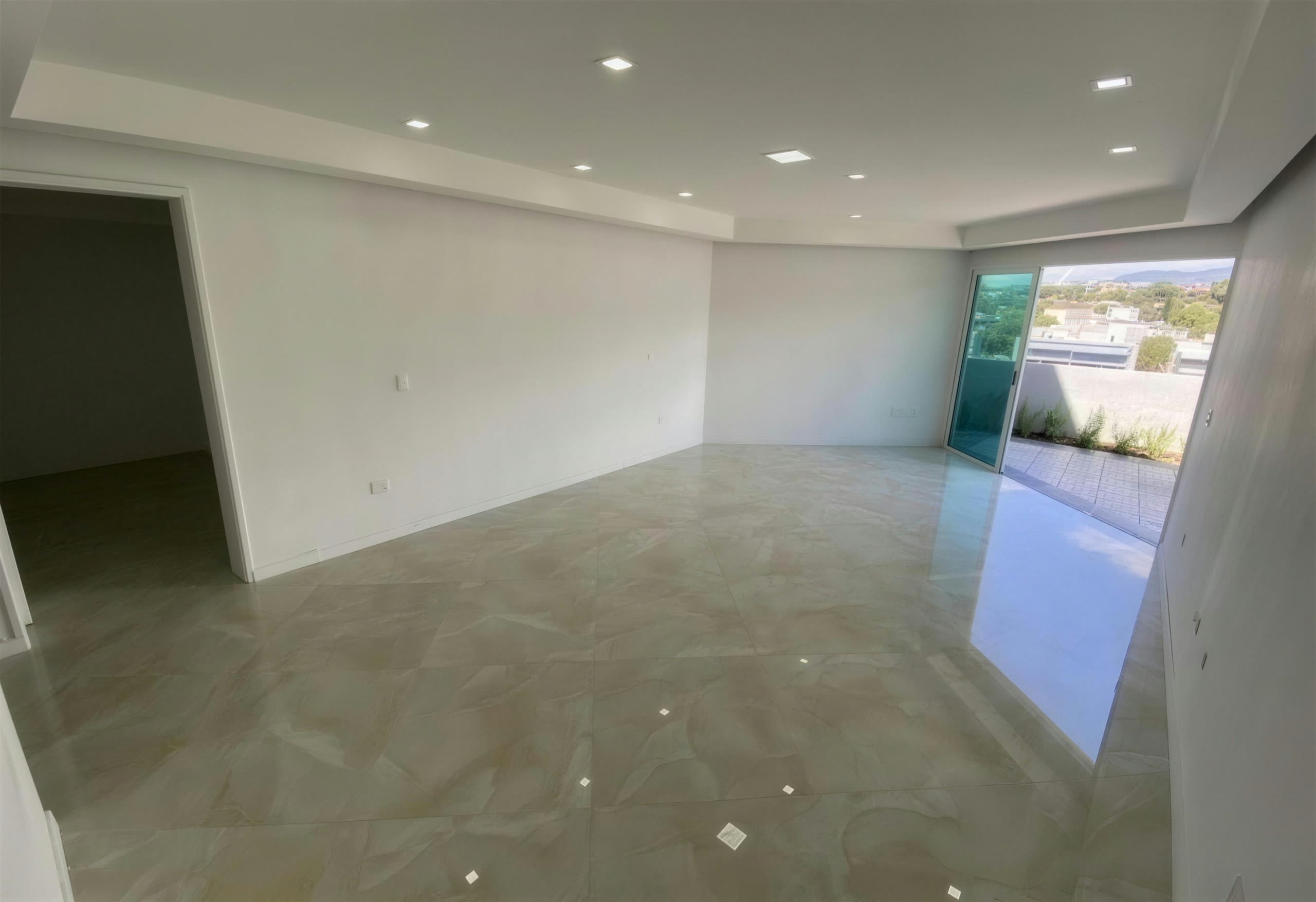 Salón con puerta de vidrio hacia la terraza